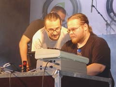 CNCD performing live. Aleksi 'Heatbeat' Eeben on the right getting ready to play some weird sounds on the C-64 with a joystick.